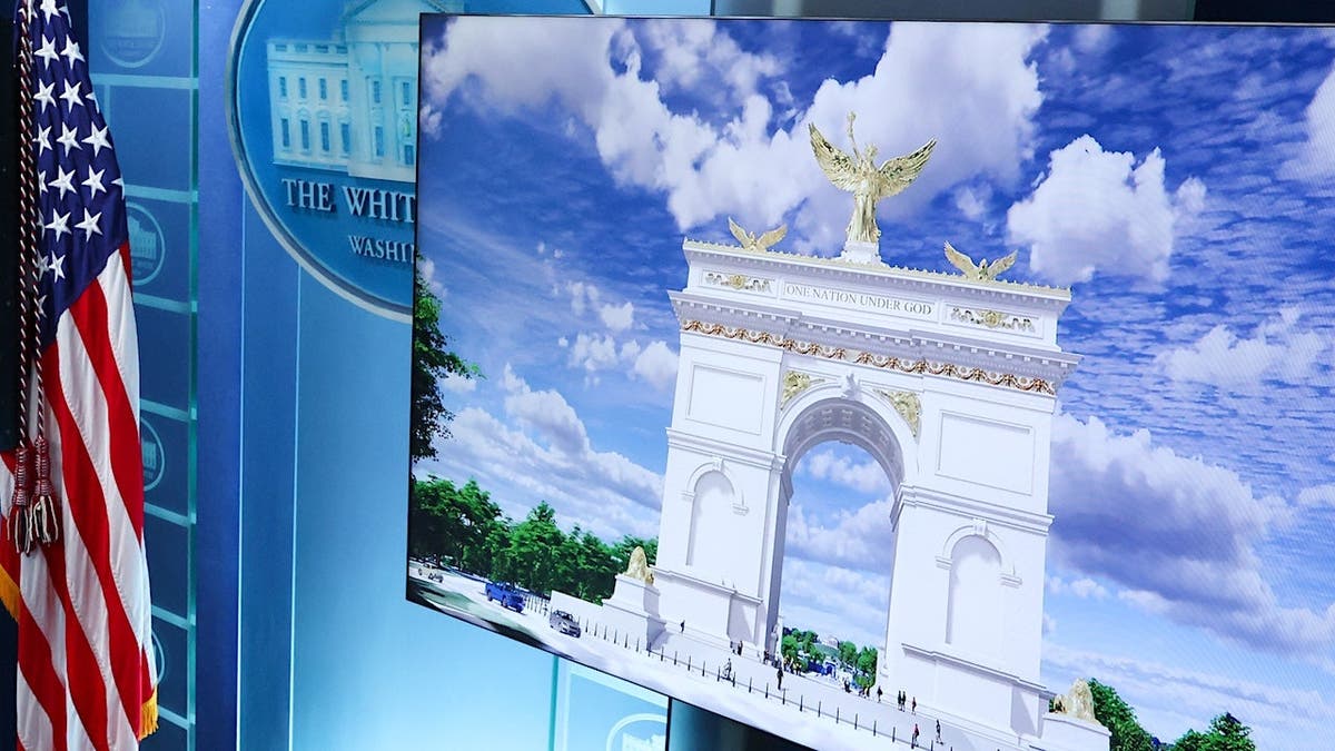 White House Press Secretary Karoline Leavitt displays a rendering of a Memorial Circle arch in a briefing room.