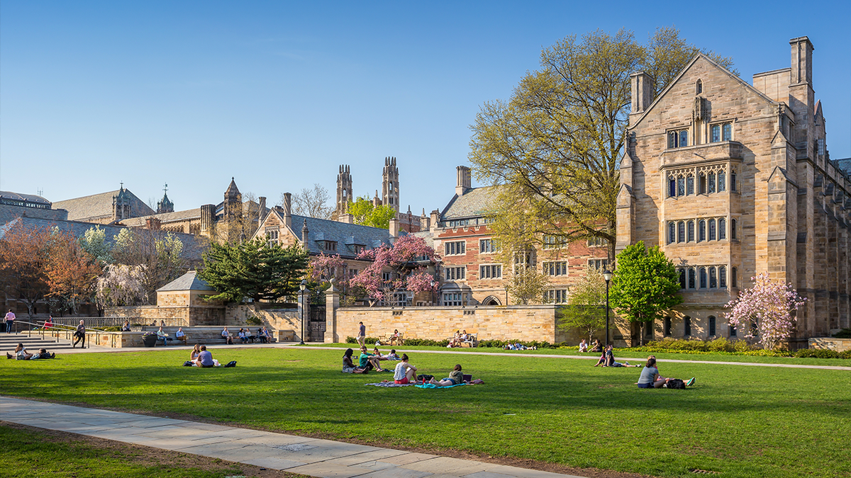 Three students sitting in the main courtyard at Yale University in New Haven, Connecticut