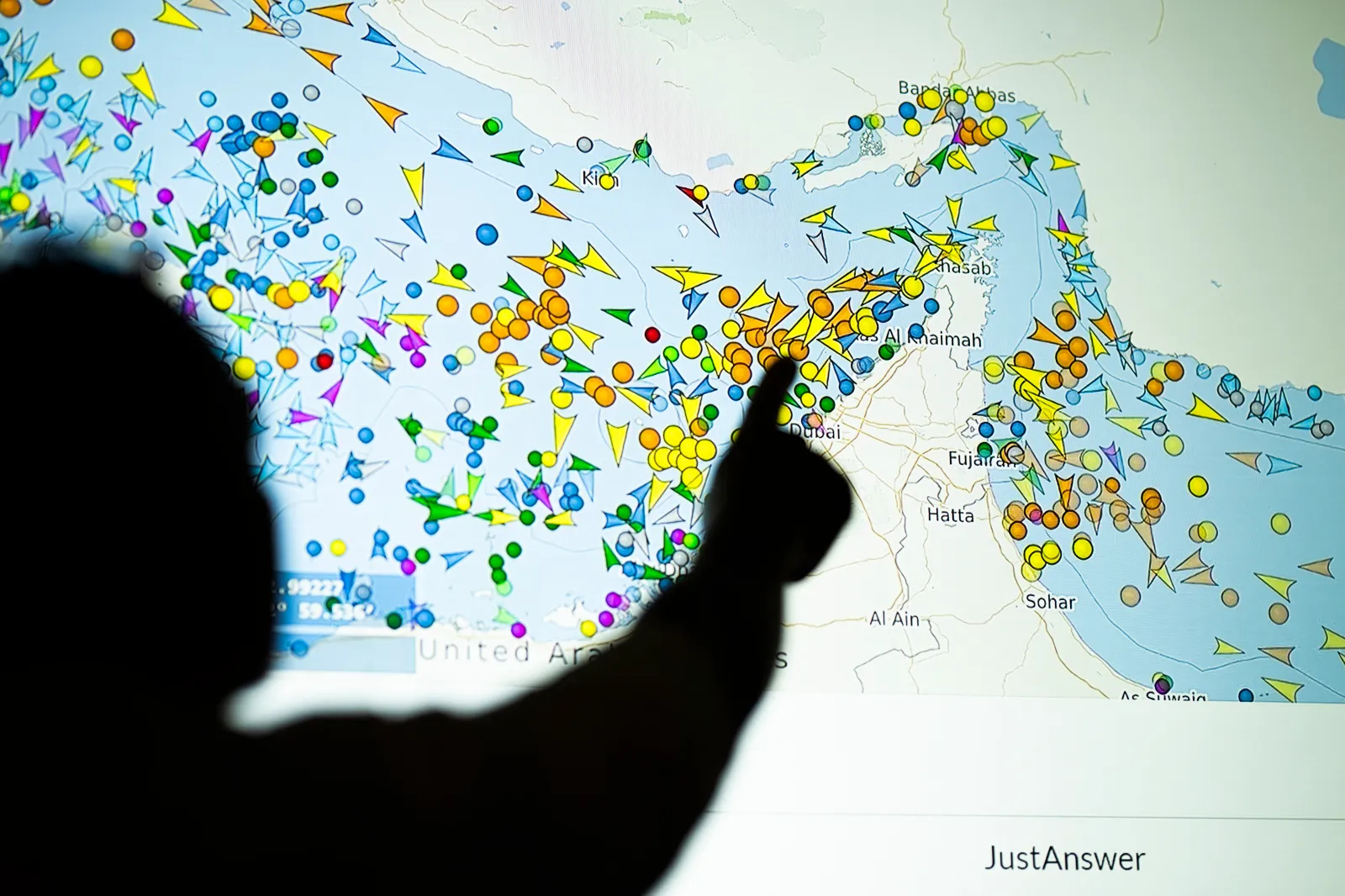 A person points in front of a large screen displaying vessel movements in the Strait of Hormuz on a ship-tracking website, on May 4, in Nicosia, Cyprus.