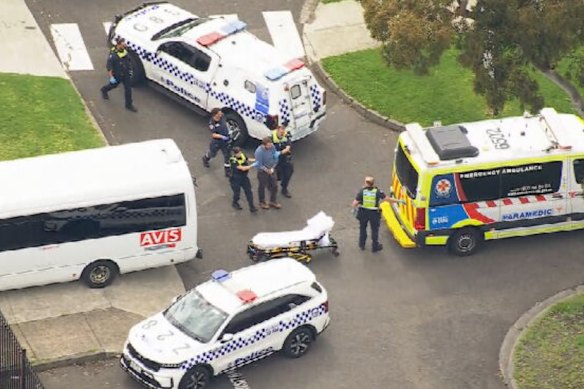 Emergency services lead Ramchen away at Keysborough Secondary College on the day of the attack.