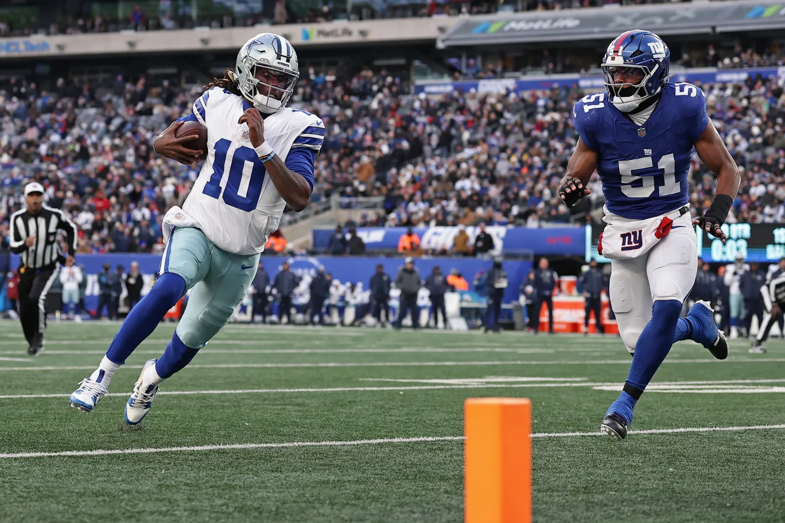 Dallas Cowboys quarterback Joe Milton III (10) runs with the ball past New York Giants linebacker Abdul Carter (51) during an NFL football game Sunday, Jan. 4, 2026, in East Rutherford, N.J. (AP Photo/Adam Hunger)