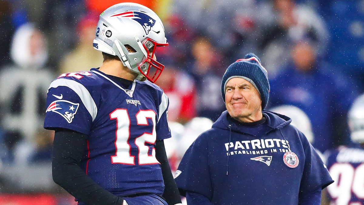 Tom Brady talks to head coach Bill Belichick on the field at Gillette Stadium