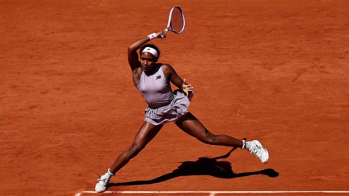US Coco Gauff hitting a forehand return to US Taylor Townsend on a tennis court.