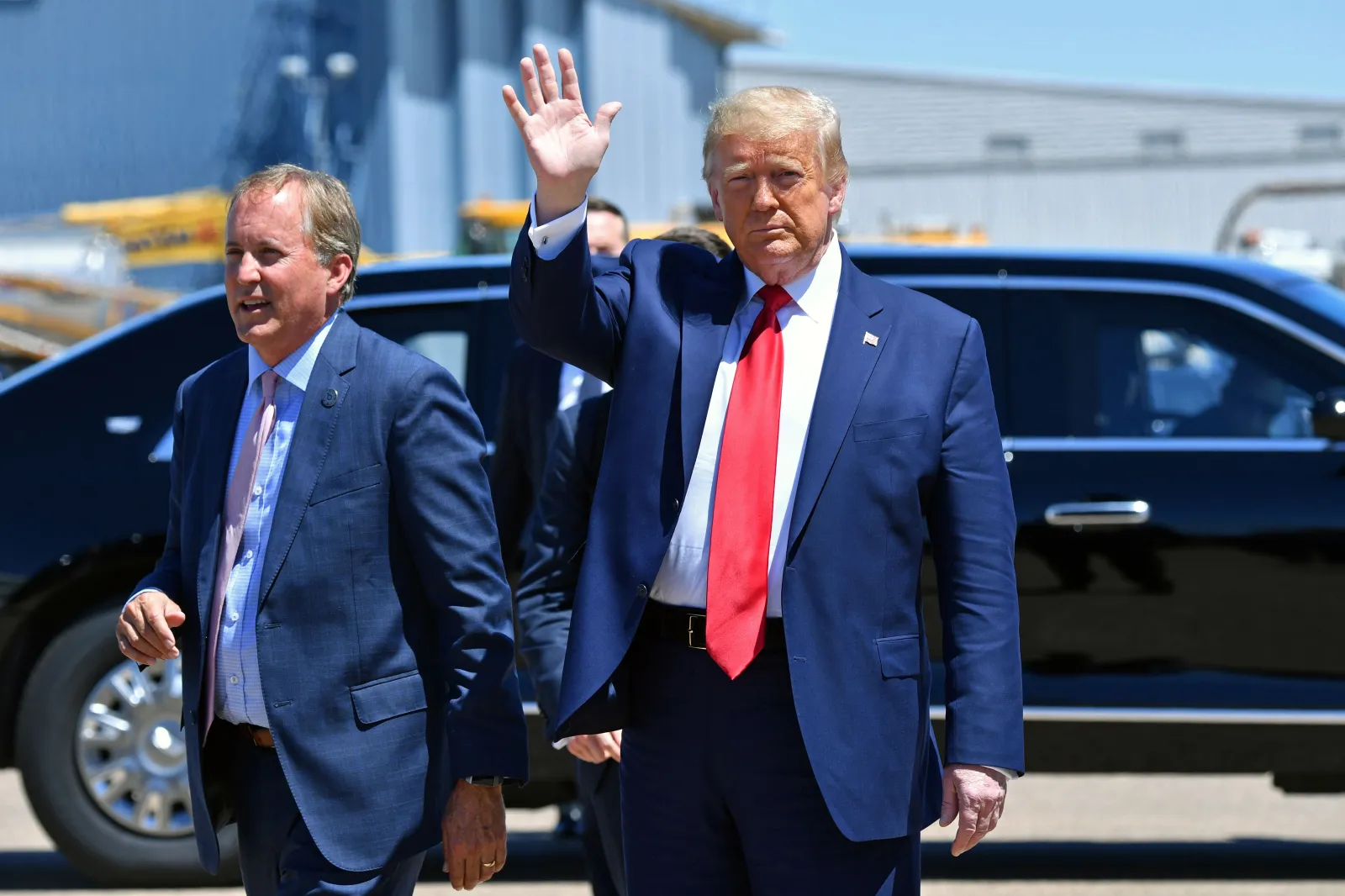President Donald Trump waves upon arrival alongside Ken Paxton, left, in Dallas on June 11, 2020. (Photo by Nicholas Kamm/AFP via Getty Images)