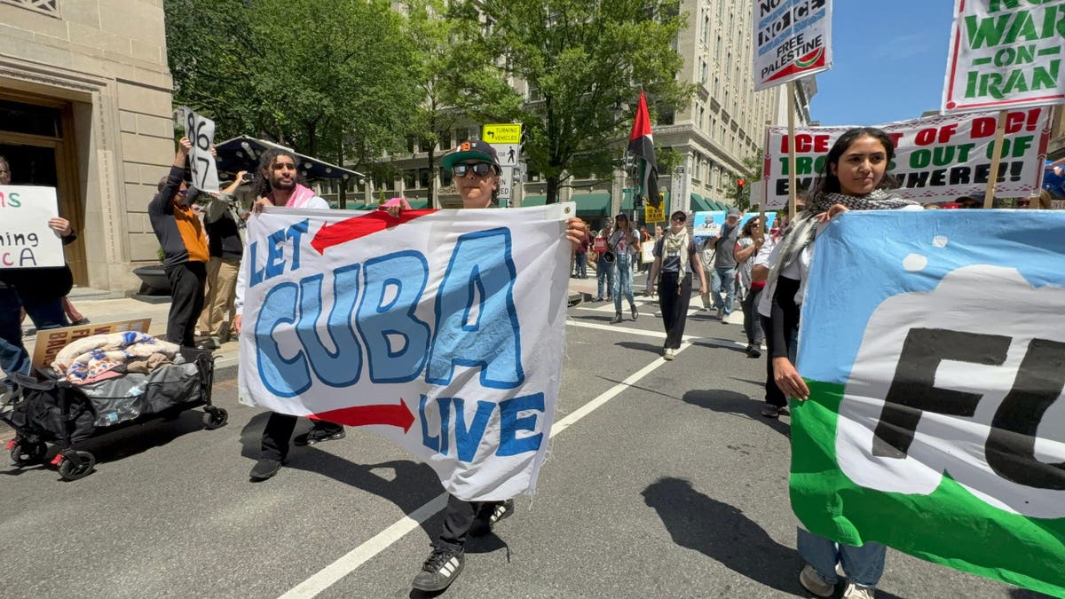 On May 1, 2026, protesters from CodePink carry a banner that says,