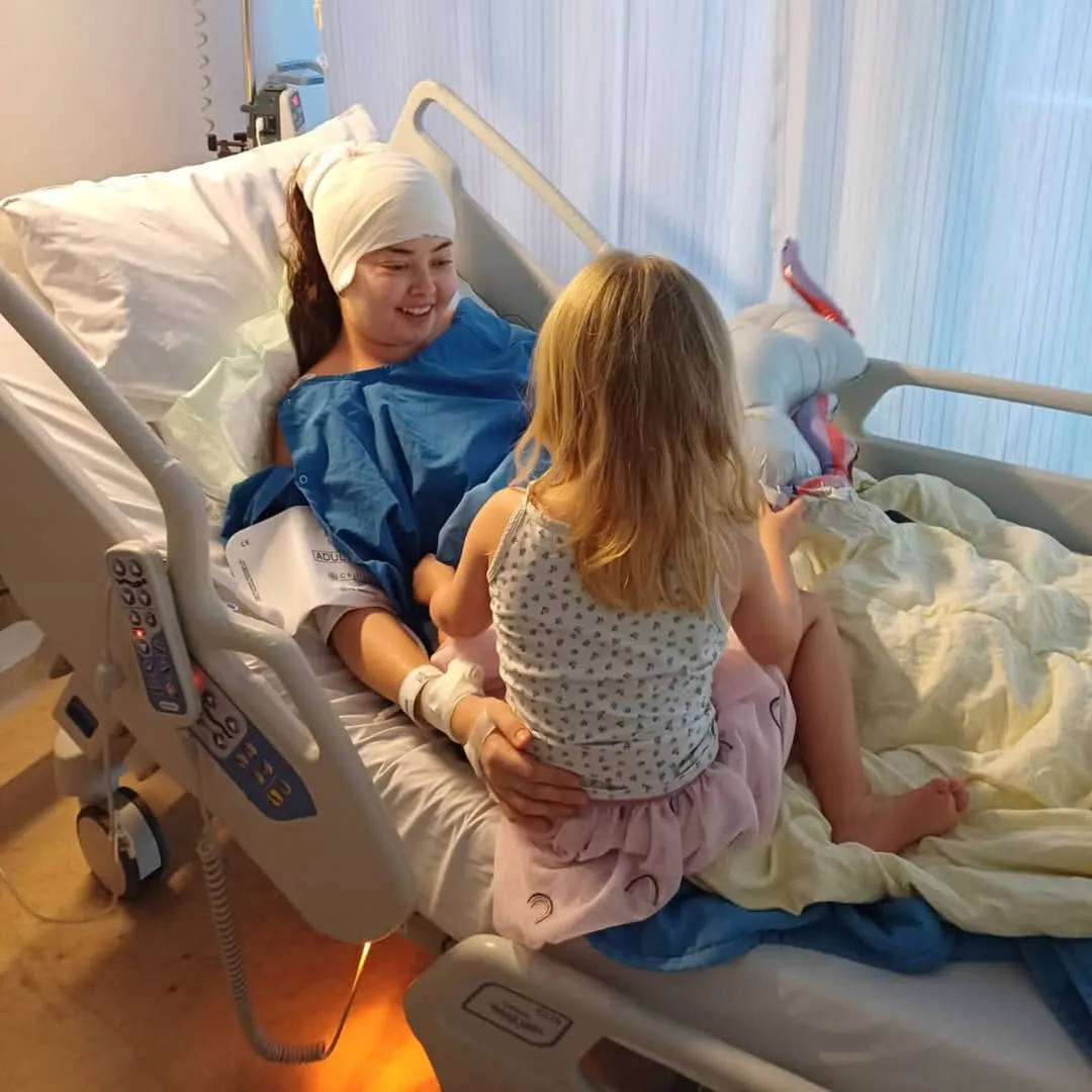 Daggett in the hospital with her daughter after her 2024 craniotomy, which removed a large part of her brain tumor.
