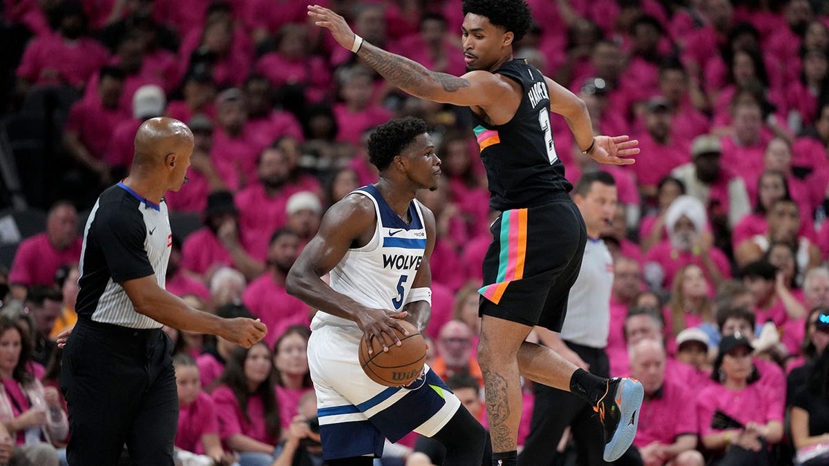 Minnesota Timberwolves guard Anthony Edwards dribbling basketball defended by San Antonio Spurs guard Dylan Harper