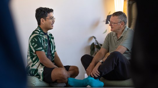 Indonesian student Arie Judanto chats to his friend with Wayne Pash after doing a yoga class.