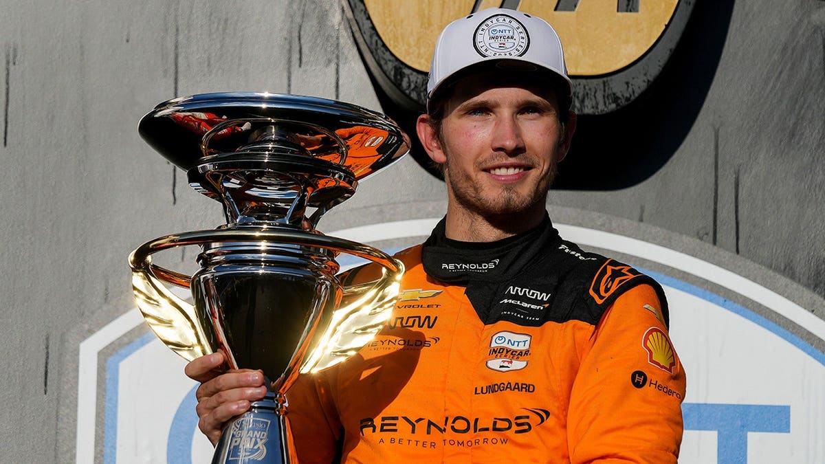 Christian Lundgaard posing with his race suit after winning the Sonsio Grand Prix