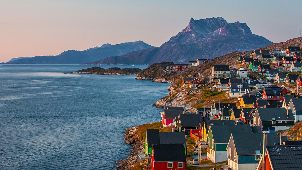 Colorful houses along rocky coast in Nuuk Greenland at sunset