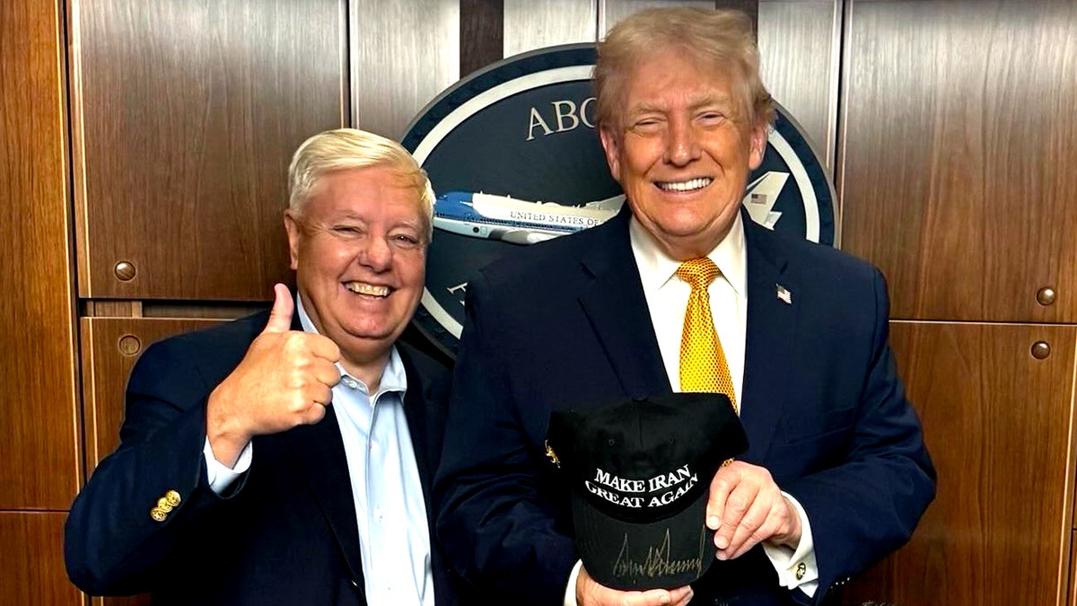 Sen. Lindsey Graham posing with President Donald Trump holding a signed Make Iran Great Again hat