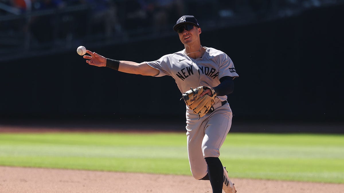 New York Yankees shortstop Anthony Volpe throwing ball to first base at Citi Field