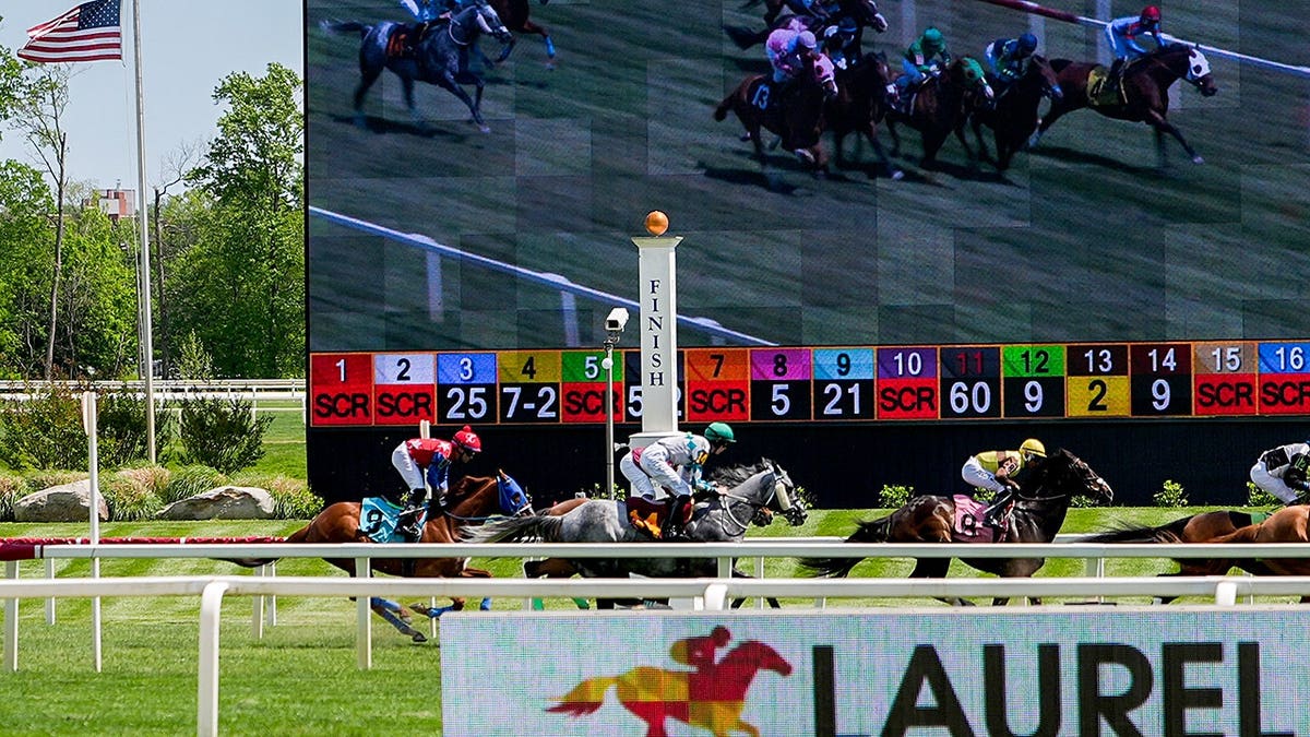 Jockeys racing horses on a dirt track at Laurel Park in Laurel, Md.