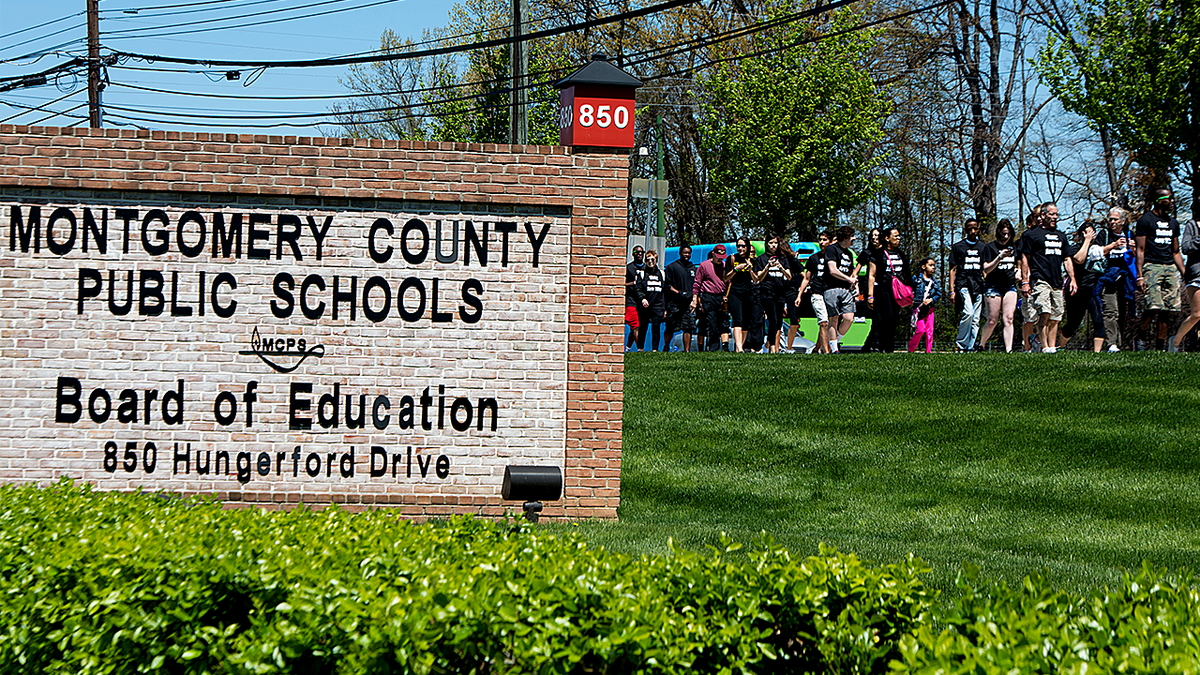 Montgomery County Public Schools building with students and parents protesting in background.