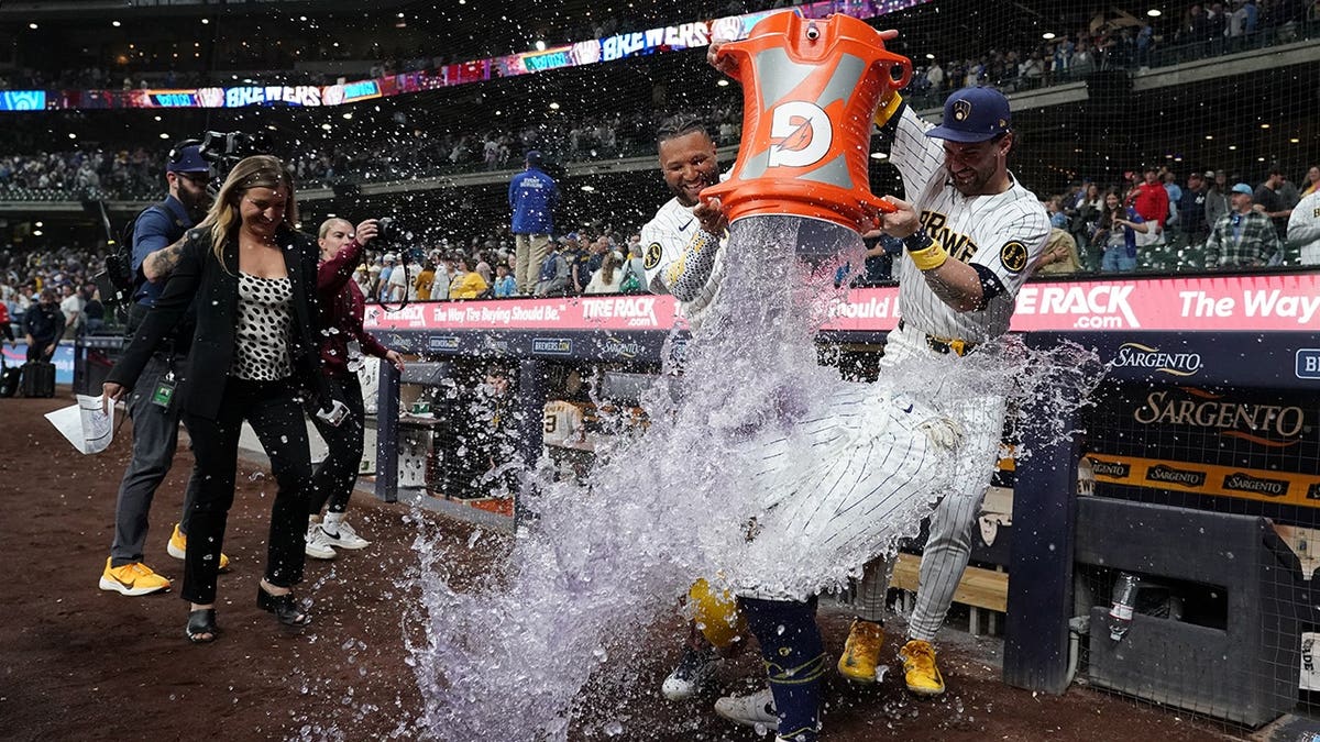 Milwaukee Brewers' William Contreras being doused by Jackson Chourio and Garrett Mitchell on baseball field