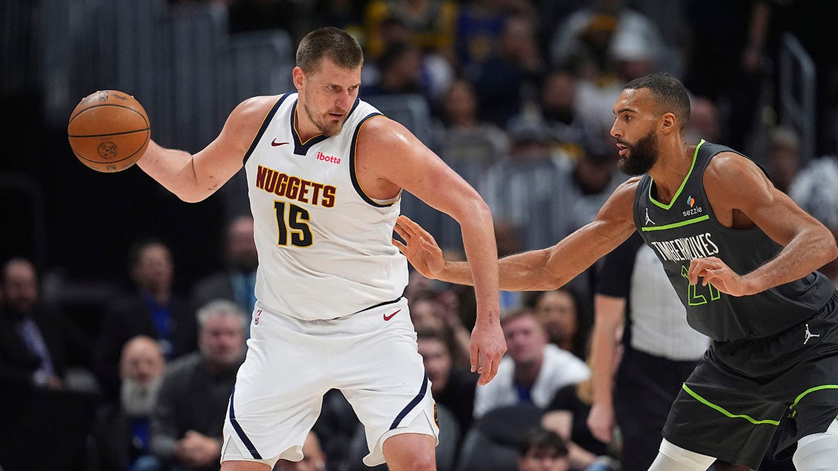 Nikola Jokic looks to pass basketball as Rudy Gobert defends in NBA game