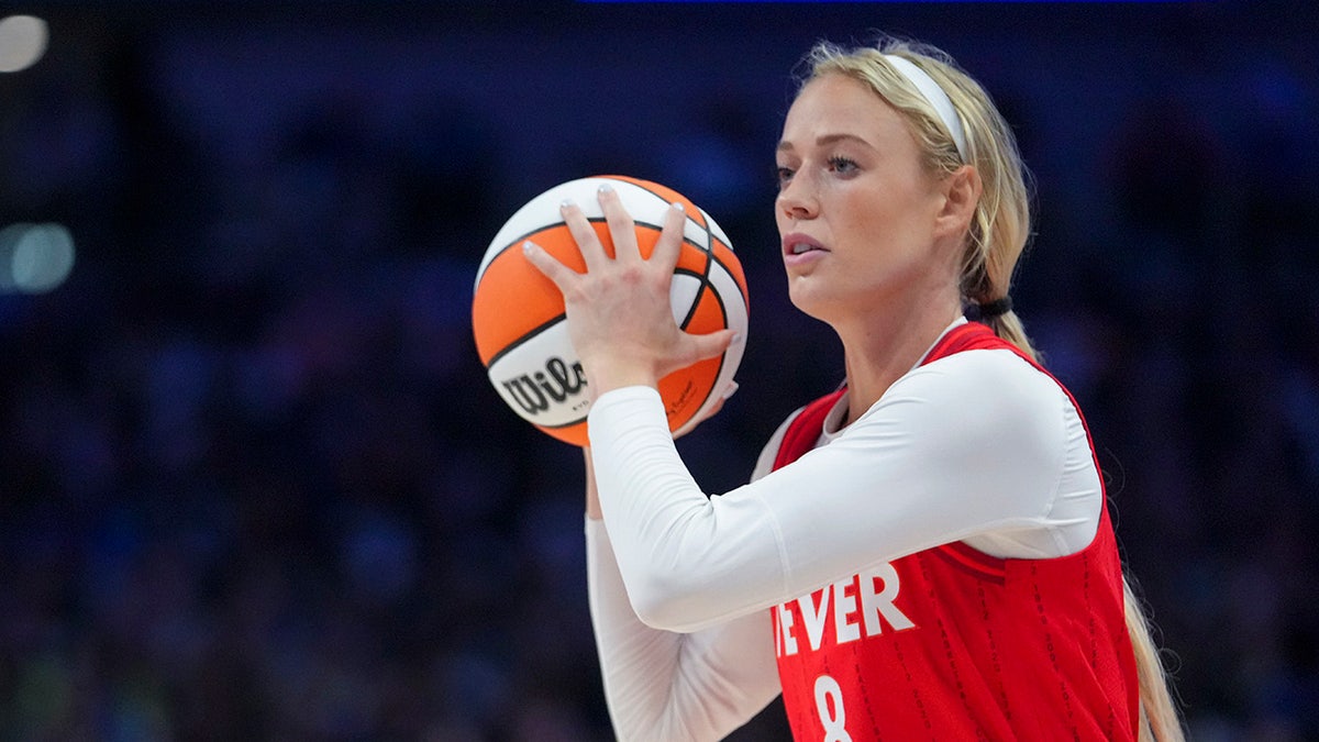 Indiana Fever guard Sophie Cunningham dribbling basketball against Dallas Wings guard Paige Bueckers
