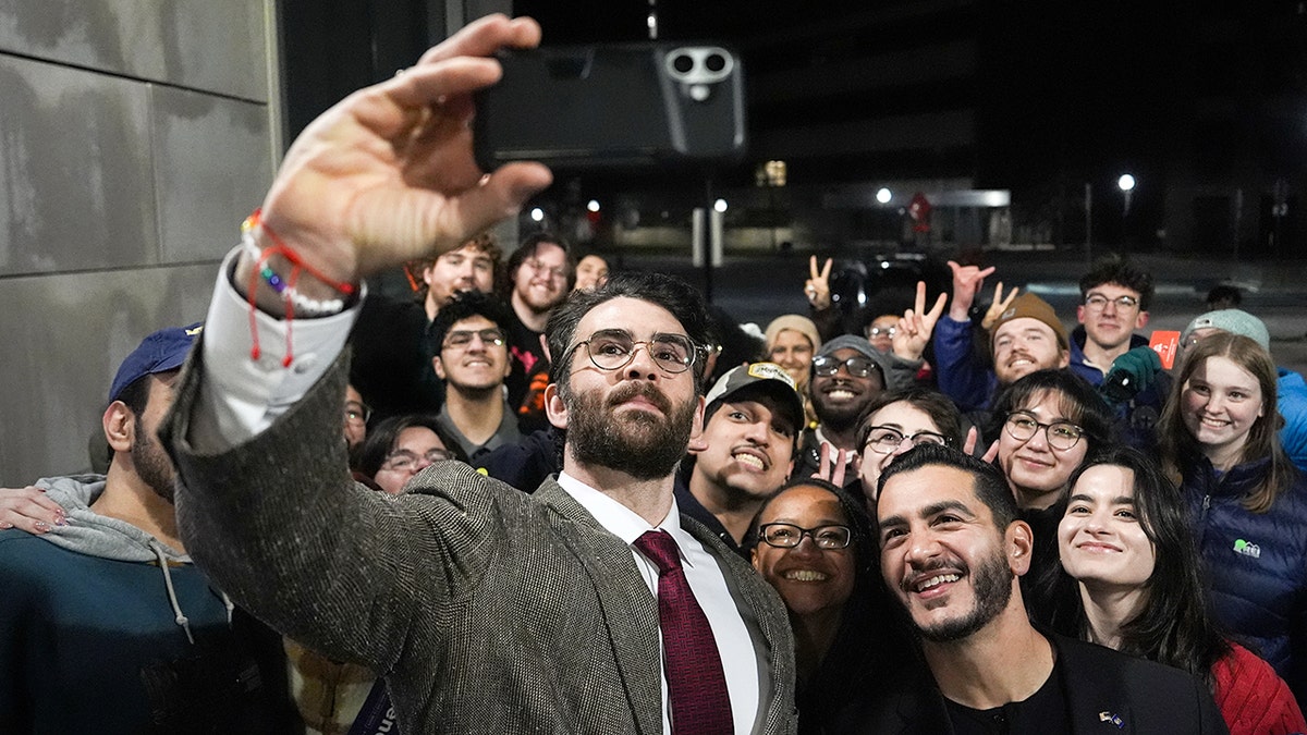 Streamer Hasan Piker and Abdul El-Sayed taking a selfie with young fans at University of Michigan