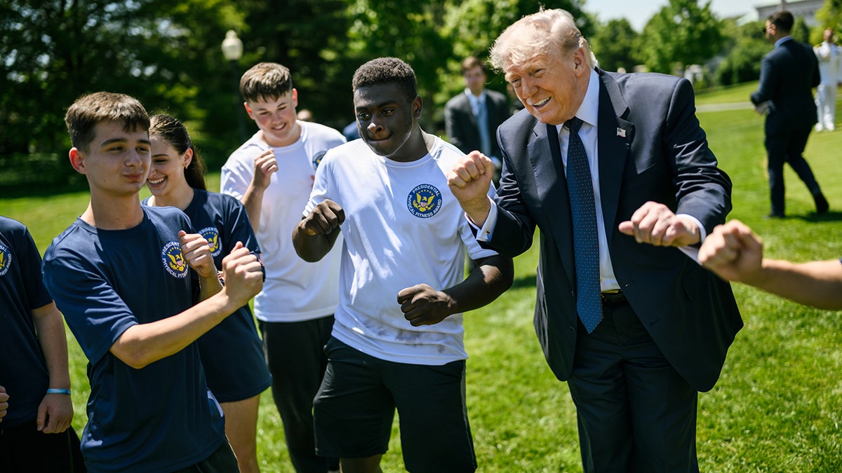 President Trump shows off his signature YMCA dance move with students.