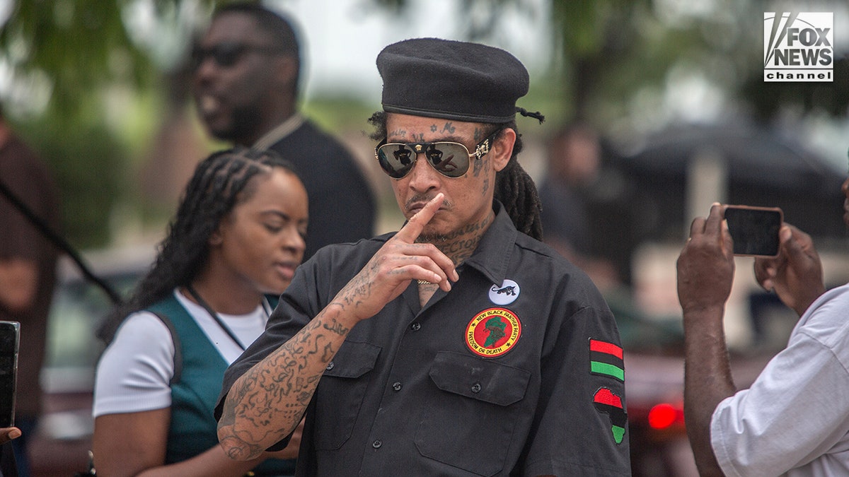 A New Black Panther Party member standing outside Collin County Courthouse in McKinney, Texas.