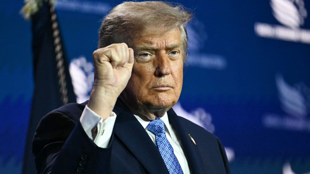 trump pumps fist in air at Faith & Freedom Coalition