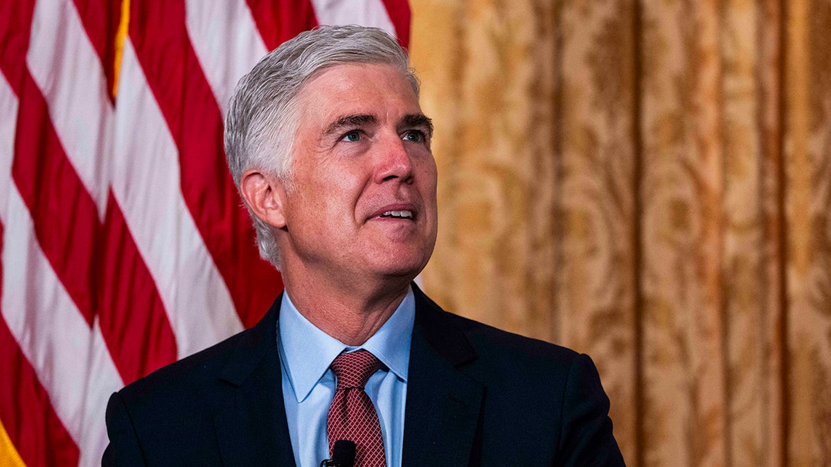 Supreme Court Justice Neil Gorsuch speaking at a podium indoors