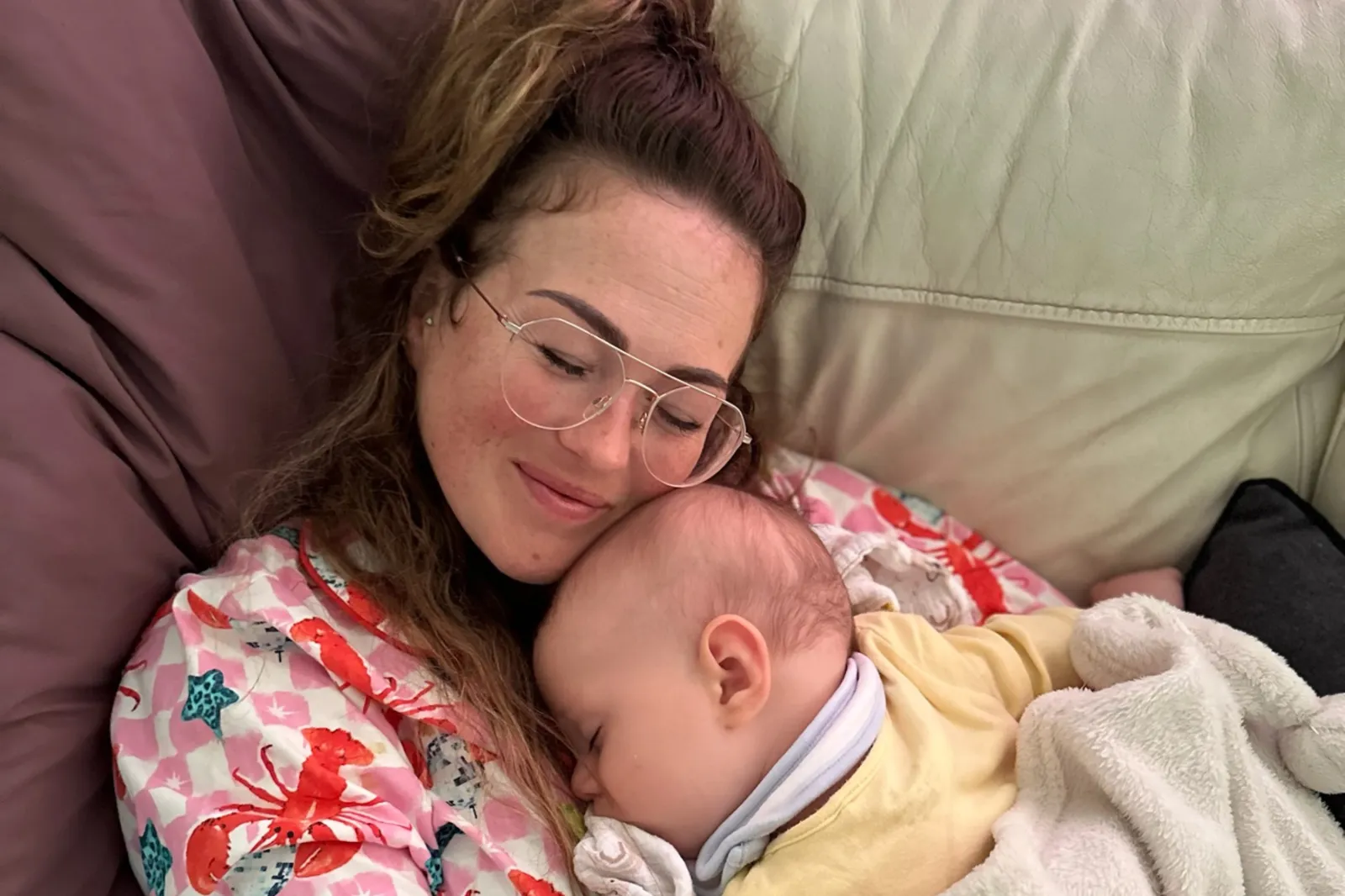 Ashlee Downie cuddling her baby boy Caruso on the couch.