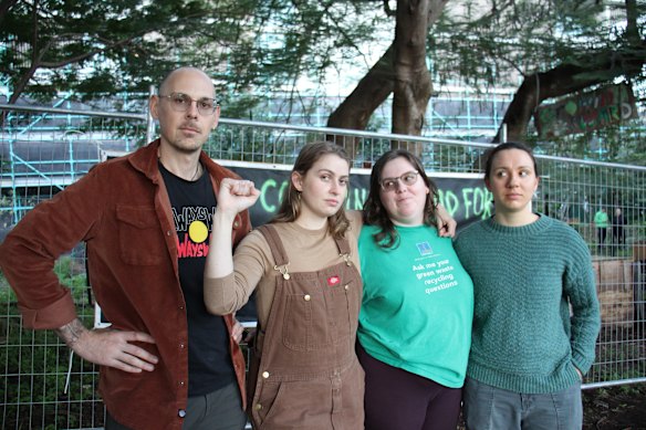 Kurilpa Commons members Shane Cucow, Jemika Lancaster and Jess Wallace at the gardens on Monday as police and government workers fenced it off. 