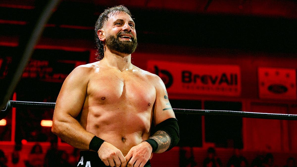 Austin Aries walks around the ring