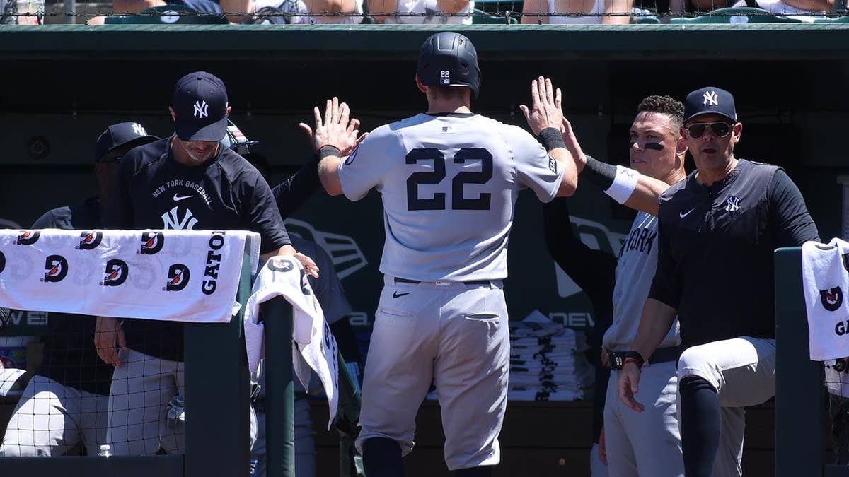 New York Yankees' Ben Rice high-fiving teammates after scoring a run