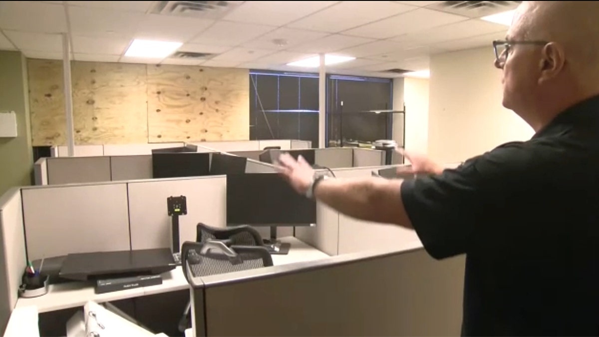Acting Field Office Director Joshua Johnson showing an office with boarded windows at Dallas ICE Field Office