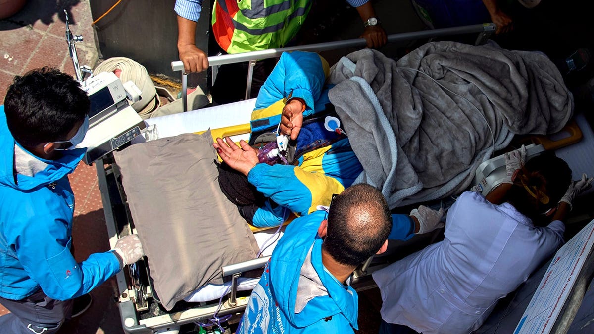 Medics carrying Dawa Sherpa on a stretcher at HAMS Hospital in Kathmandu