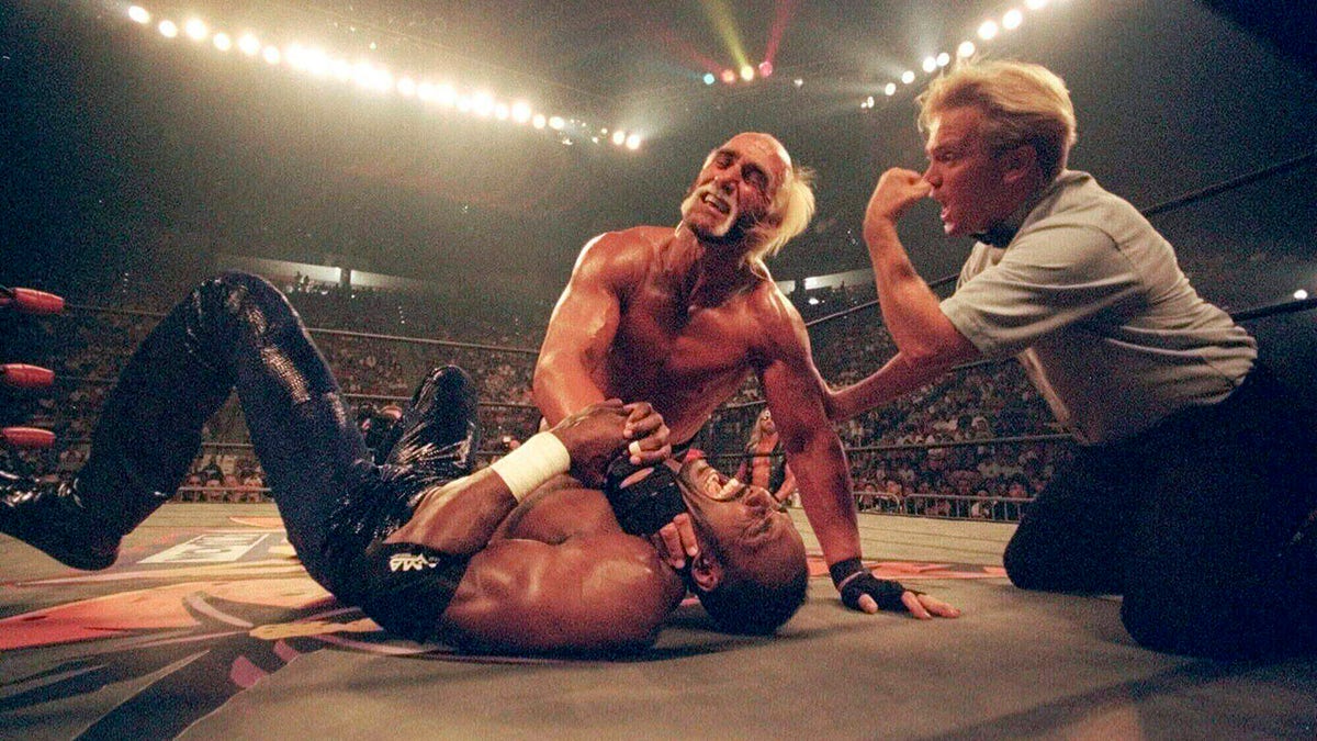 Hulk Hogan putting a choke hold on Karl Malone during a wrestling match