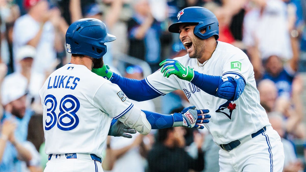 George Springer celebrating with Nathan Lukes at Rogers Centre in Toronto