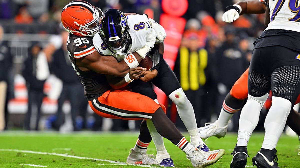 Myles Garrett #95 of the Cleveland Browns sacks Lamar Jackson #8 of the Baltimore Ravens during the second quarter at Huntington Bank Field on November 16, 2025 in Cleveland, Ohio. (Photo by Jason Miller/Getty Images)
