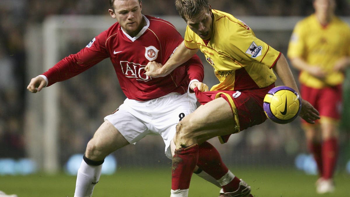 Jay Demerit holds off a challenge from Wayne Rooney. (Richard Heathcote/Getty Images)