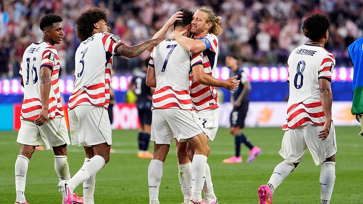 United States' Giovanni Reyna celebrating with teammates after scoring a goal in a soccer match.