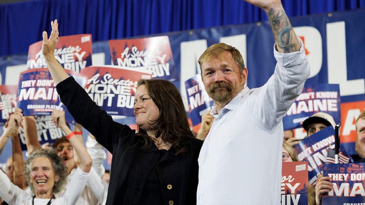 Democratic U.S. Senate candidate Graham Platner and his wife Amy Gertner waving to supporters in Blue Hill, Maine