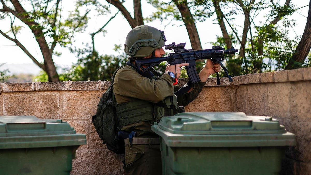 Israeli soldier scanning area while taking cover near Israel-Lebanon border