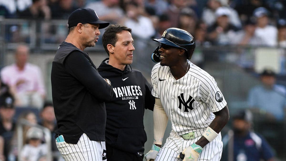New York Yankees second baseman Jazz Chisholm Jr. receiving medical attention on his lower leg at Yankee Stadium.