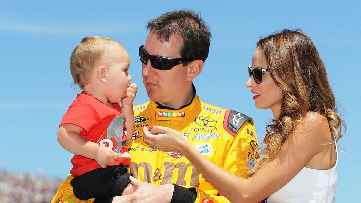 Kyle Busch holding his son Brexton next to his wife Samantha at Michigan International Speedway
