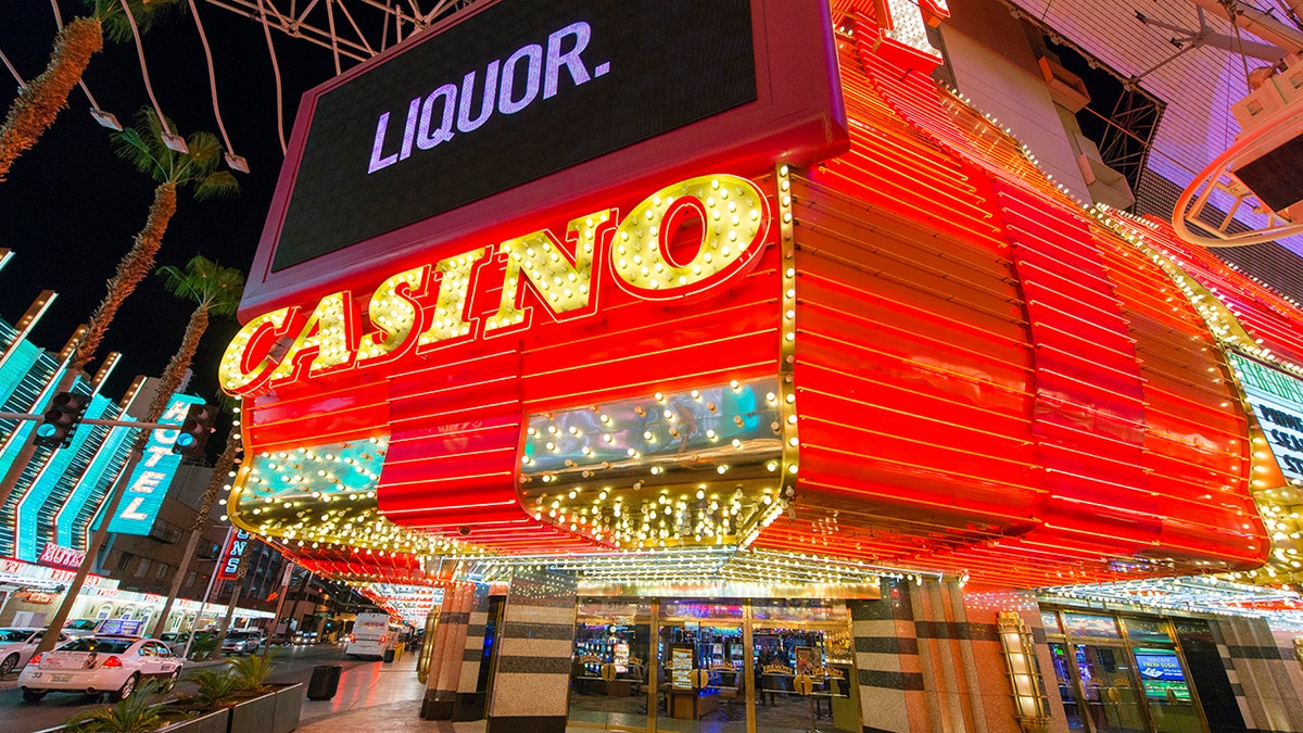 Large neon casino and liquor sign lit up at night on Fremont Street in Las Vegas