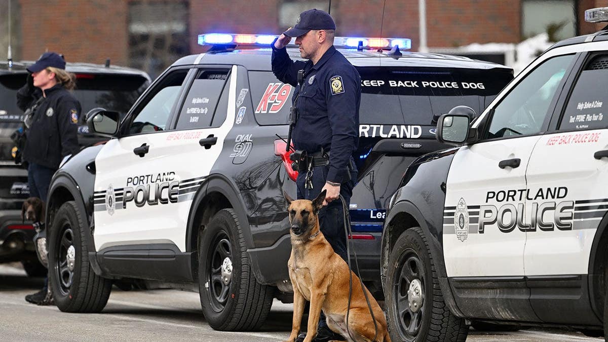 Portland Police Officer Tom Reagan and K-9 Bedi standing outside during funeral procession.