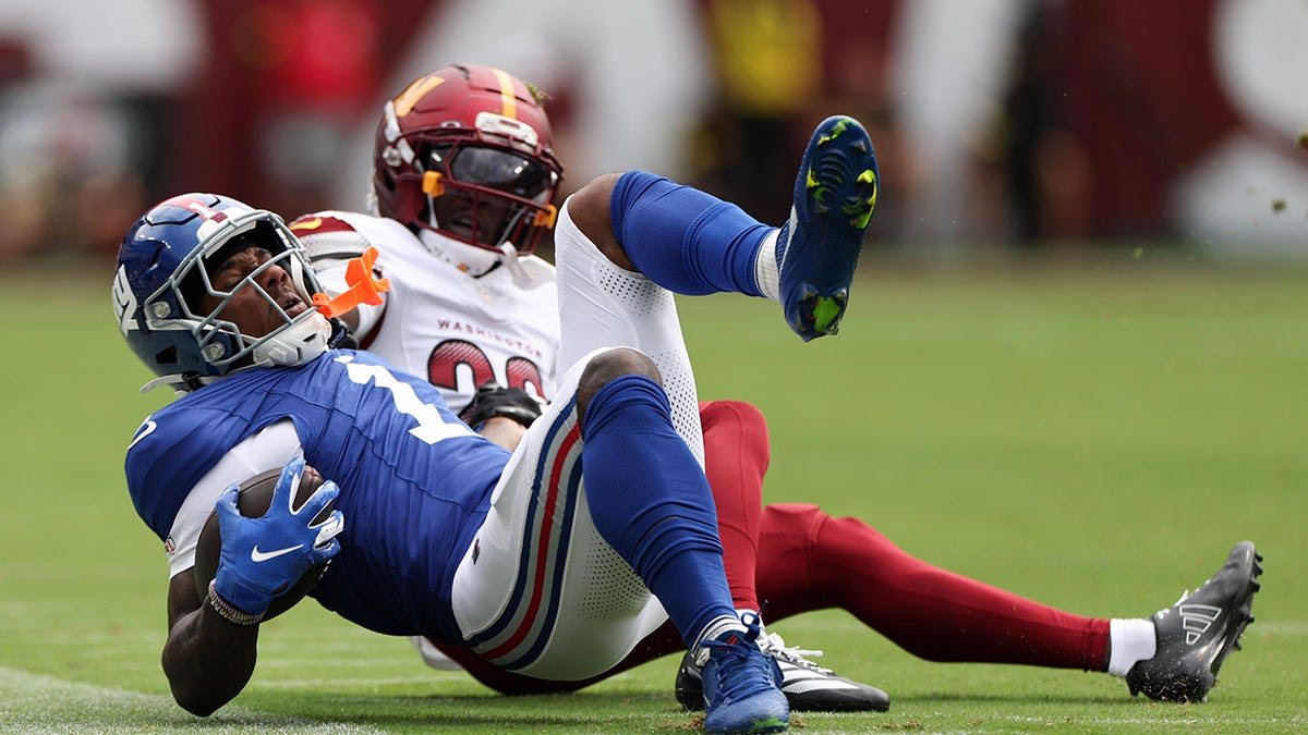 Malik Nabers of the New York Giants tackled by Mike Sainristil during a football game