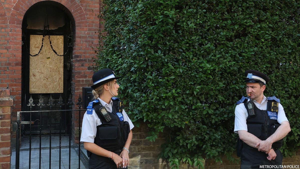 officers stand outside home