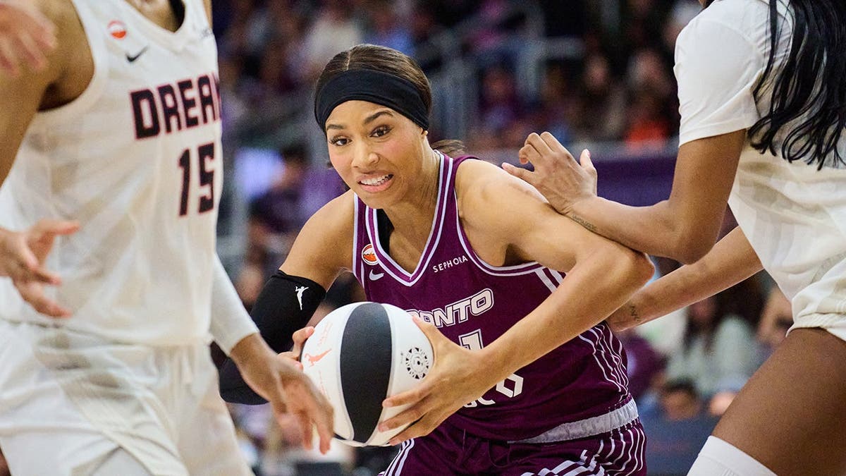 Toronto Tempo's Isabelle Harrison driving past Atlanta Dream's Angel Reese during a basketball game