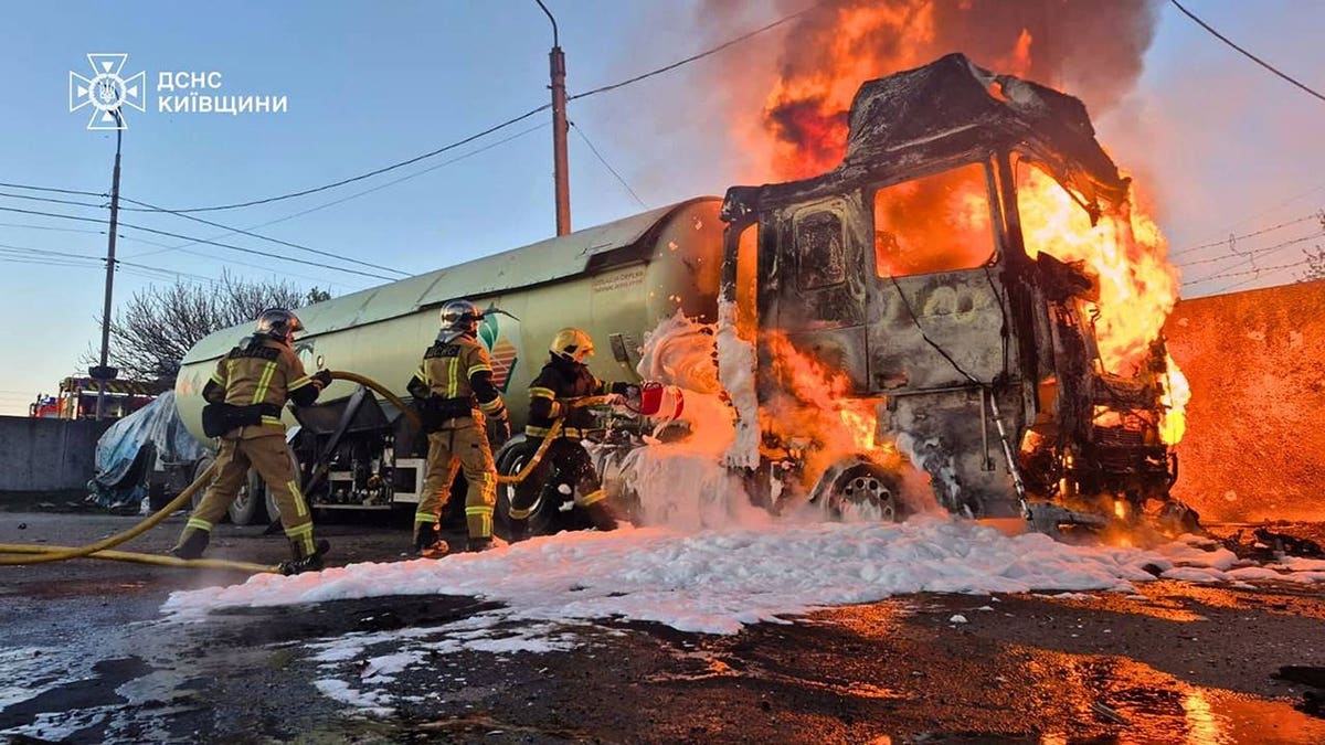 Emergency services personnel extinguishing fire on vehicle in Kyiv region