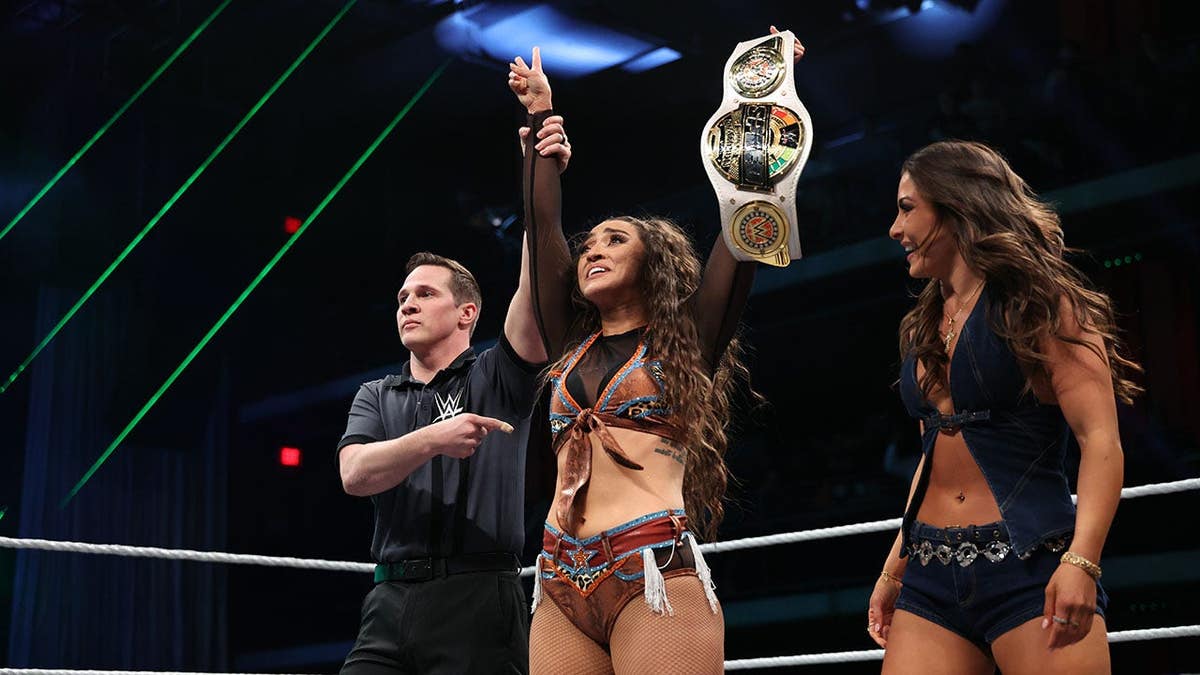 Wren Sinclair holding WWE Women's Speed Championship belt in Houston venue.