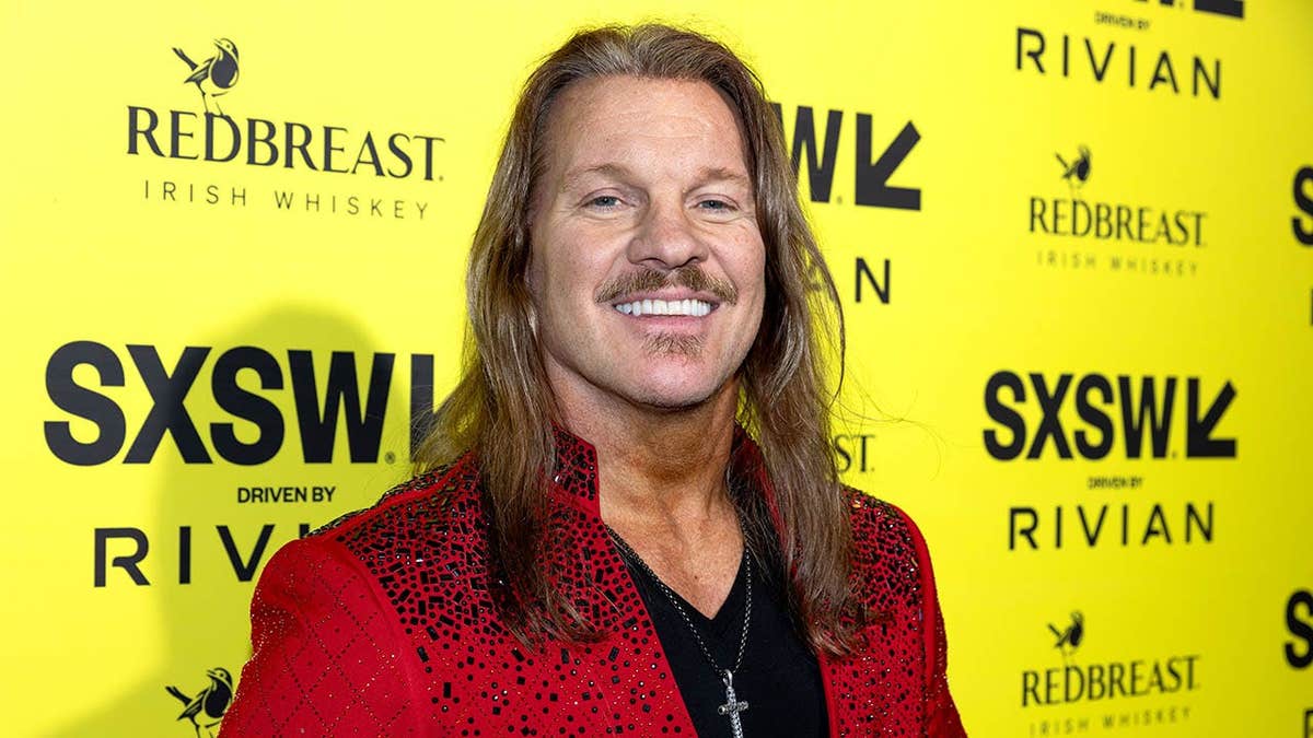 Chris Jericho stands at a premiere backdrop in Austin, Texas.