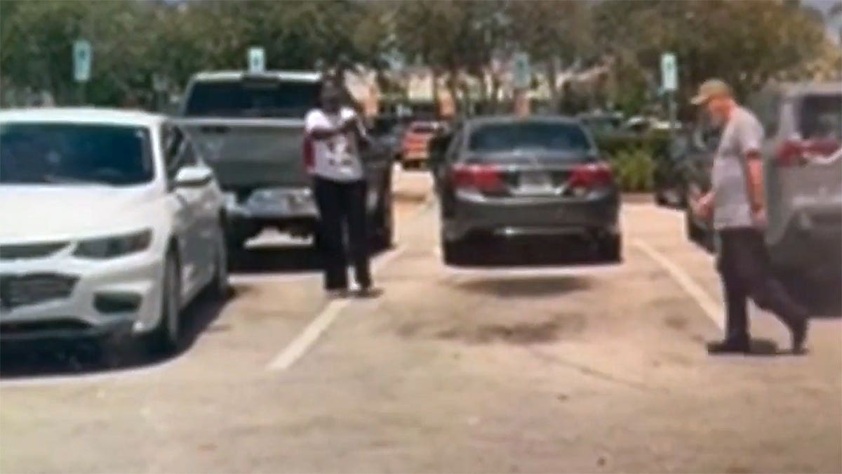 A woman raises her arm toward Bart Diguglielmo during a confrontation in a Walmart parking lot moments before the fatal shooting.